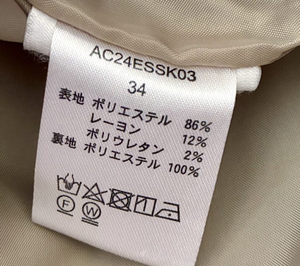 タイトスカートの品質表示タグ。サイズ34（XS相当）、ポリウレタン2%配合の伸縮素材