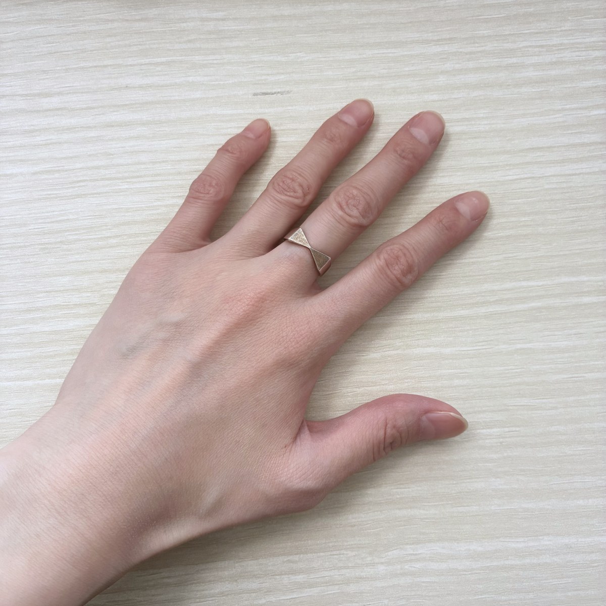 AJIROのシルバー925リボンリングを中指につけた手元